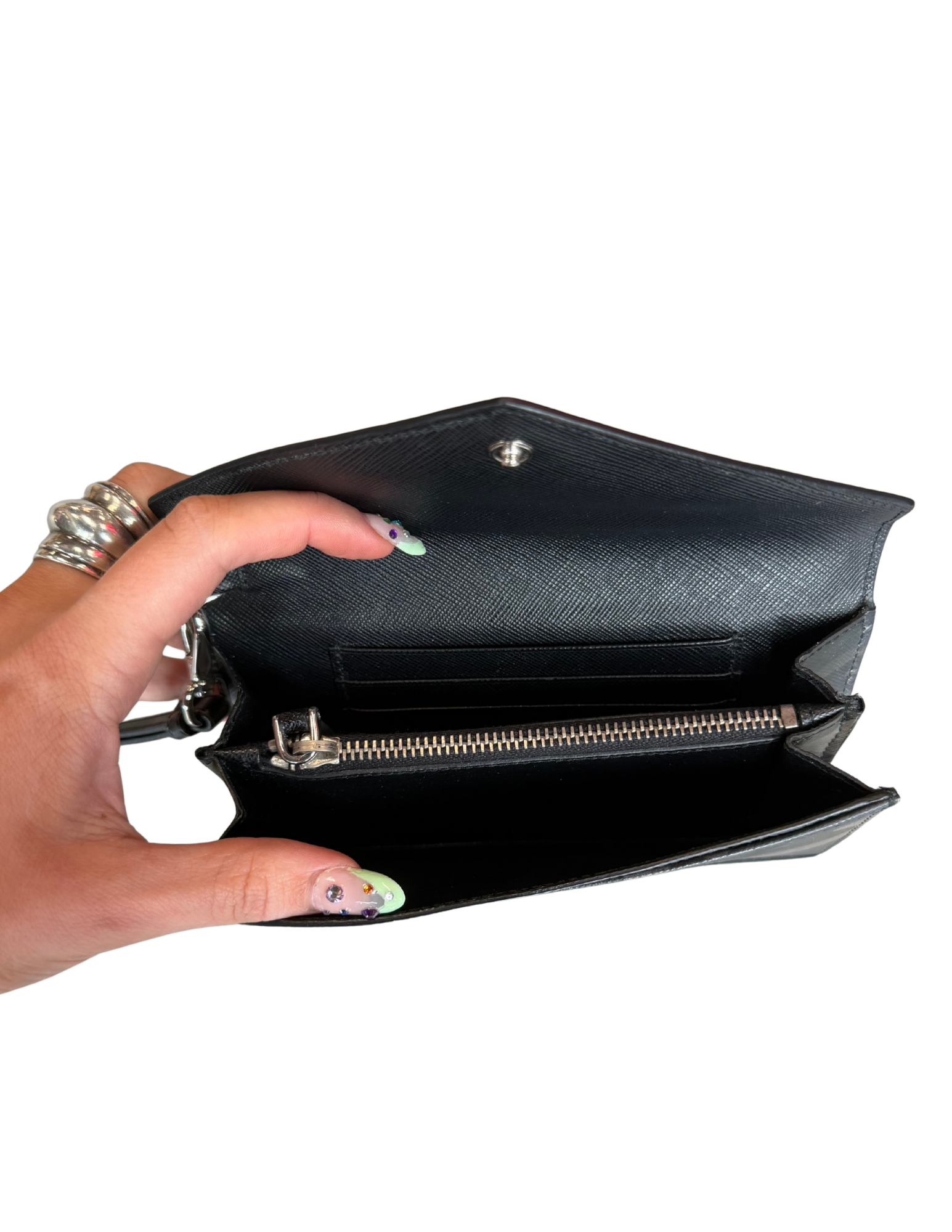 Hand holding a black clutch bag with a white background