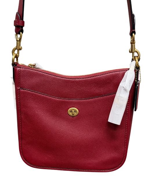 Red leather handbag with gold accents on a white background